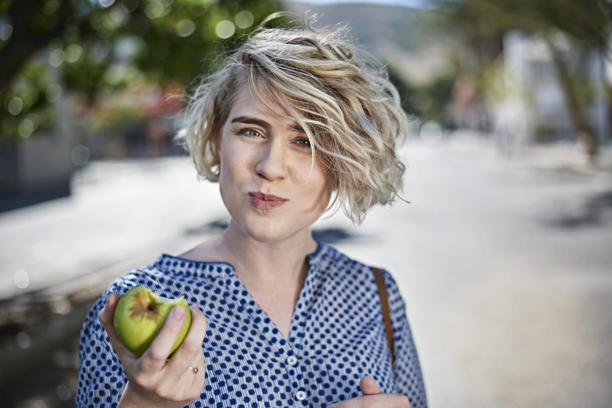 Woman eating an apple. (Getty Images)