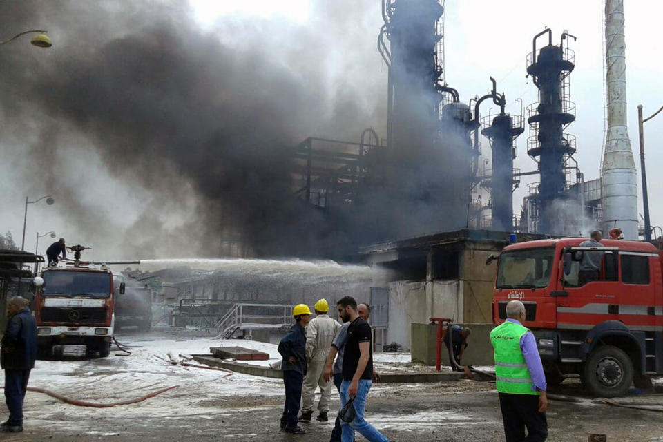 In this photo released by the Syrian official news agency SANA, firefighters put out a fire at the Homs Oil Refinery in the central province of Homs, Syria, Sunday, May. 9, 2021. The fire came amid a series of mysterious attacks on vessels and oil facilities in Syria over the past months. The war-torn country has been suffering from fuel shortages in recent months. (SANA via AP)