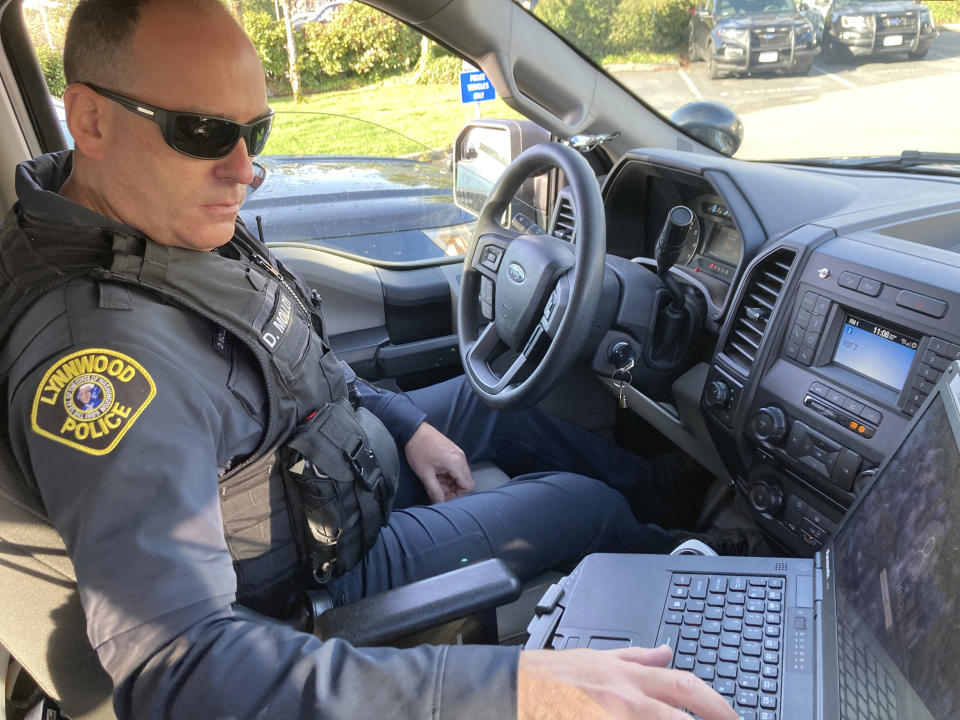 Lynnwood police Officer Denis Molloy works in his vehicle, Wednesday, Nov. 17, 2021, in Lynnwood, Wash. Molloy, of the Lynnwood Police Department's community health and safety section, says that navigating recent police reforms in Washington State has been challenging. (AP Photo/Gene Johnson)