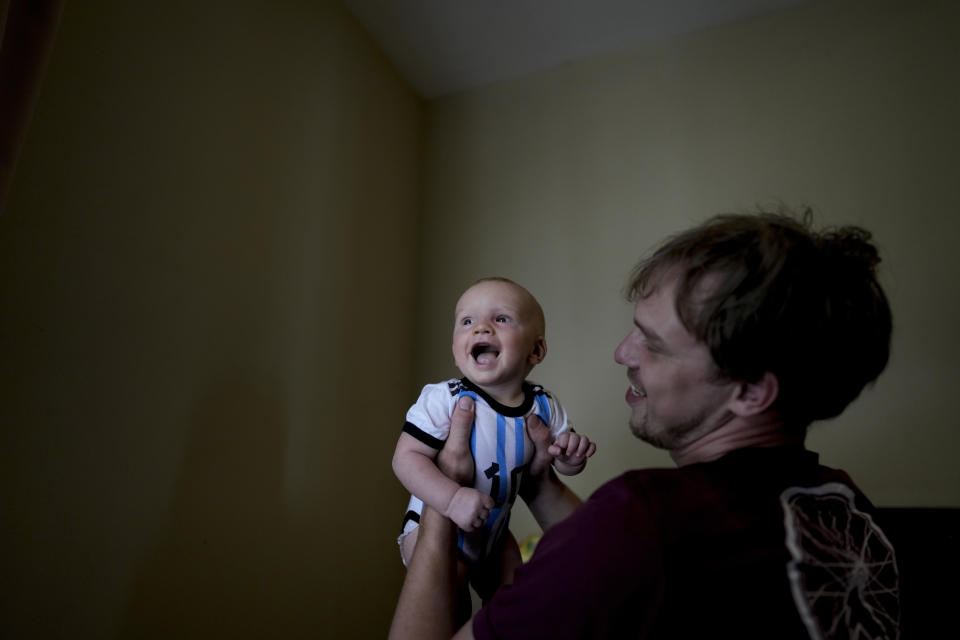 Andrei Ushakov lifts his Argentine-born son Lev Andres, in their home in Mendoza, Argentina, Tuesday, Feb. 14, 2023. Ushakov had been detained in Russia for holding up a sign that read “Peace,” and his pregnant wife feared he would soon be drafted and potentially killed, leaving their baby fatherless. They fled their home in Sochi choosing Argentina as their new home.(AP Photo/Natacha Pisarenko)