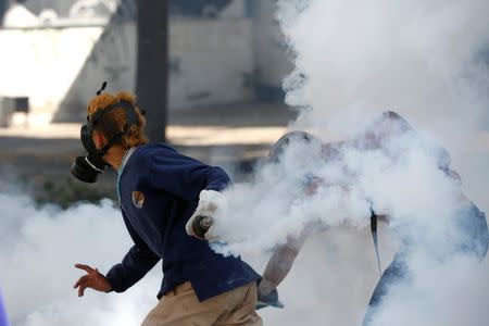 A demonstrator prepares to throw a tear gas at a rally during a strike called to protest against Venezuelan President Nicolas Maduro's government in Caracas. REUTERS/Andres Martinez Casares