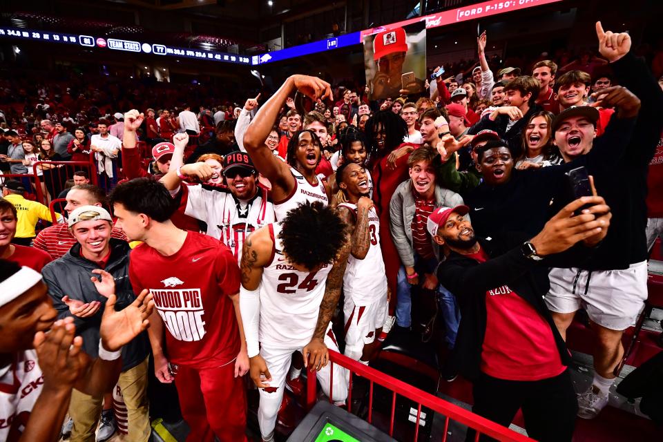 Arkansas basketball players celebrate along side fellow students after the Razorbacks defeated Purdue 81-77 in overtime of Saturday's exhibition.