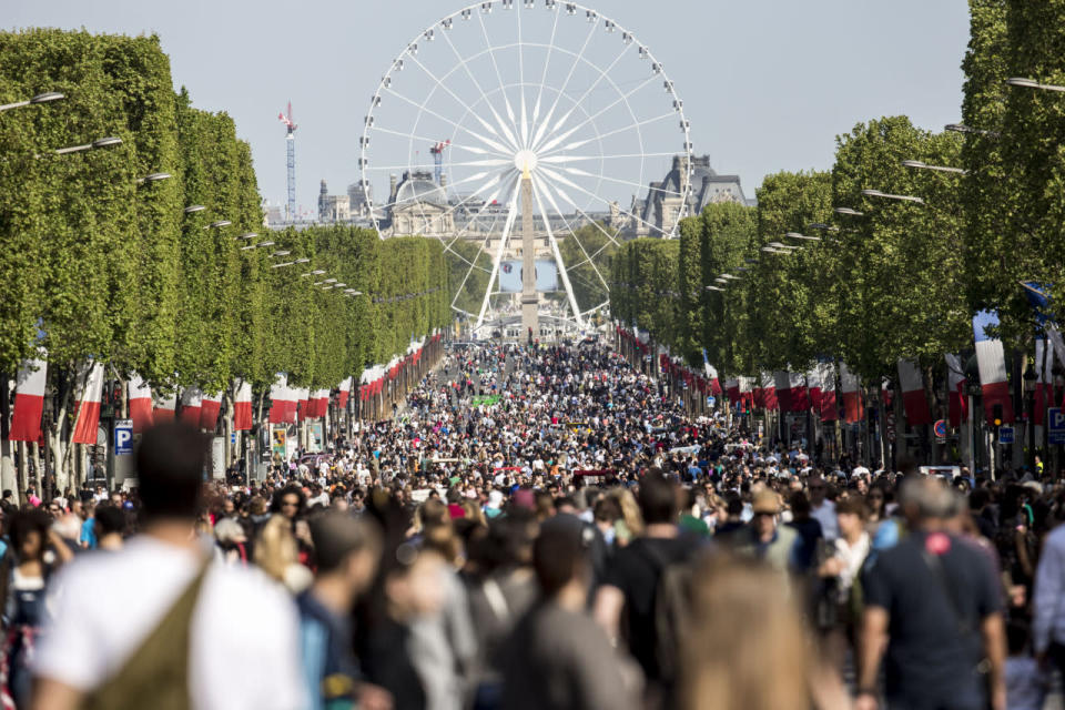 People walk on the Champs Elysees in Paris, France, May 8, 2016. Pedestrians have taken over the Champs Elysees as part of a new program to ban traffic from the famous Paris avenue once a month. The initiative, for what is usually one of the busiest roads in the French capital, was launched by Paris Mayor Anne Hidalgo and is aimed at reducing pollution in the city. (Kamil Zihnioglu/AP)