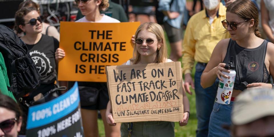 Activists display placards during a rally to mark Earth Day at Lafayette Square, Washington, Saturday, April 23, 2022.