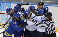 Referee jumps in to break up a scuffle between Sweden and Finland players during the second period of their women's ice hockey playoffs quarter-final game at the Sochi 2014 Winter Olympic Games February 15, 2014. REUTERS/Laszlo Balogh (RUSSIA - Tags: SPORT ICE HOCKEY OLYMPICS)