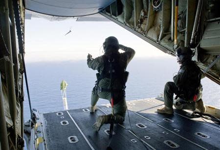 Royal Australian Air Force (RAAF) Loadmasters, Sergeant Adam Roberts (L) and Flight Sergeant John Mancey, launch a 'Self Locating Data Marker Buoy' from a C-130J Hercules aircraft in the southern Indian Ocean during the search for missing Malaysian Airlines flight MH370 in this picture released by the Australian Defence Force March 21, 2014. REUTERS/Australian Defence Force/Handout