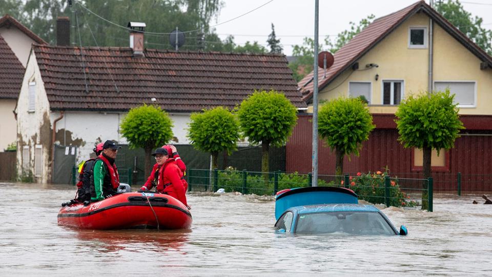 The water rescue service drives through a flooded street in an inflatable boat.  After heavy rainfall in recent days, the region is flooded.