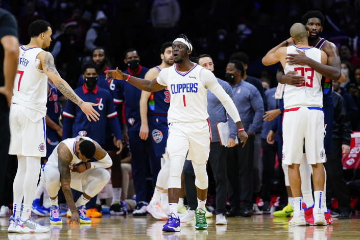 Los Angeles Clippers' Reggie Jackson (1) celebrates with Los Angeles Clippers' Amir Coffey (7) after the Clippers won an NBA basketball game against the Philadelphia 76ers, Friday, Jan. 21, 2022, in Philadelphia. (AP Photo/Matt Slocum)
