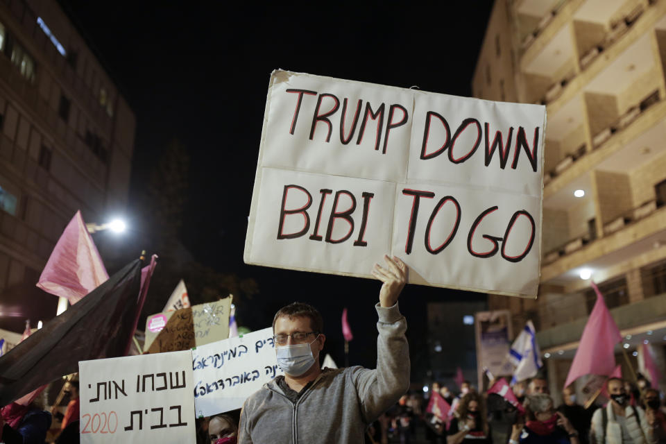 An Israeli protester holds a sign calling for the ouster of Prime Minister Benjamin Netanyahu, using his nickname "Bibi," shortly after results of the U.S. presidential election were announced, during a protest against Netanyahu in Jerusalem, Saturday, Nov. 7, 2020. Thousands of Israelis protested against Netanyahu, a close ally of Trump, demanding he step down because of his handling of the coronavirus crisis and the corruption charges he faces. (AP Photo/Maya Alleruzzo)