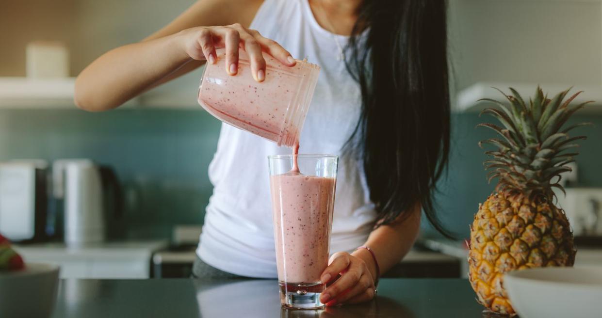 Woman preparing fresh fruit smoothie