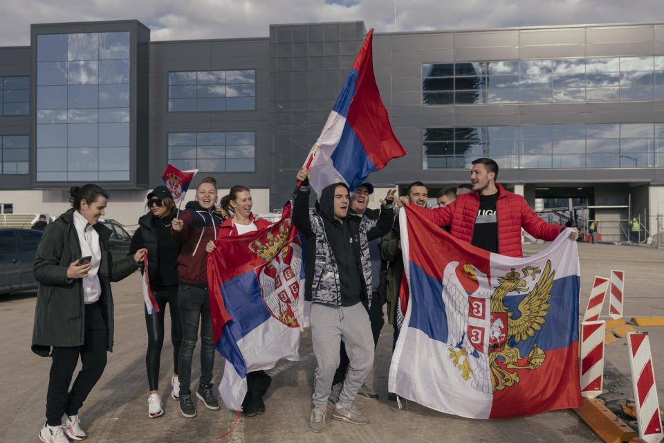 Supporters, pictured here holding Serbian national flags as they wait for the arrival of Novak Djokovic.