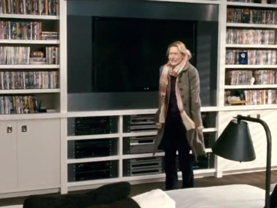 iris jumping up and down in front of amandas dvd collection in the holiday