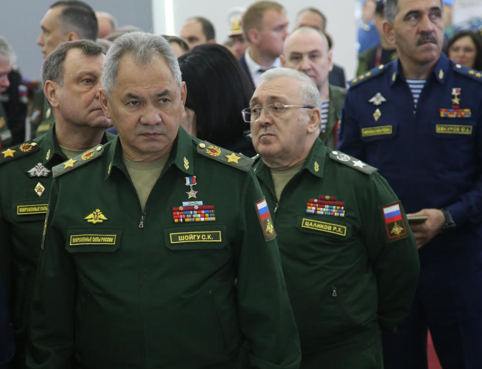 Russian Defense Minister Sergei Shoigu and deputy defense ministers stand as they visit an army exhibition.