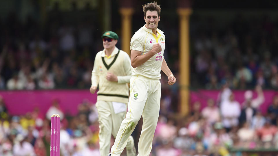 Pat Cummins celebrates after taking a wicket, pumping his fist.