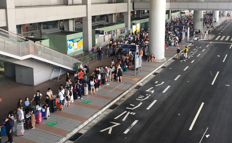 颱風燕子4日襲日本，關西國際機場淹水癱瘓，大量旅客滯留，隔日有許多旅客排隊等著搭巴士離開機場。（中央社資料照／民眾提供）