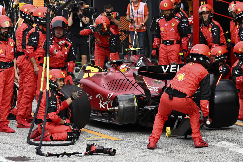 Ferrari mechanics wait for a tire to mount on the car of driver Carlos Sainz of Spain during the Formula One Dutch Grand Prix auto race, at the Zandvoort racetrack, in Zandvoort, Netherlands, Sunday, Sept. 4, 2022. (Christian Bruna/Pool via AP)