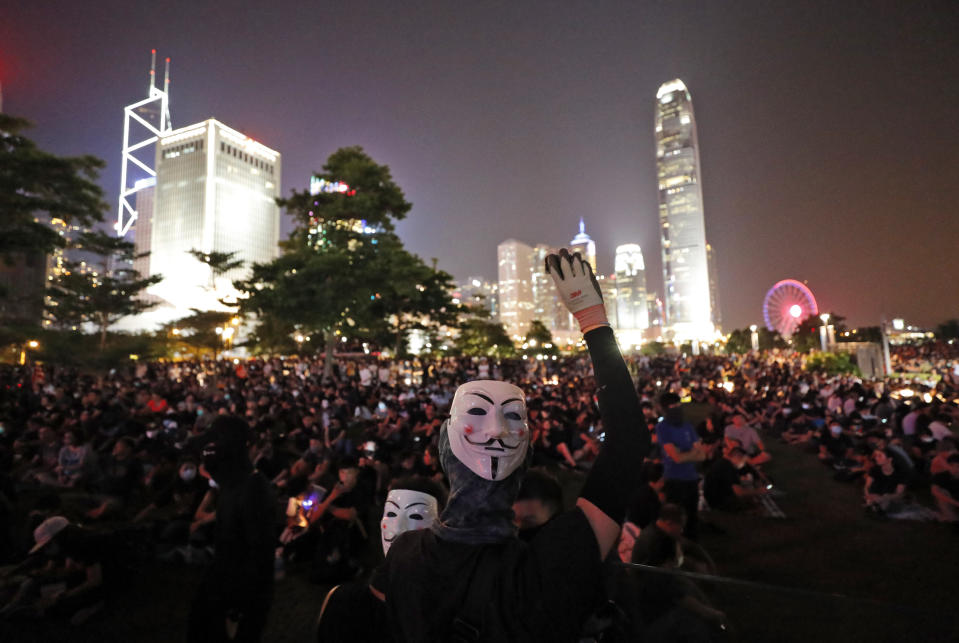 A protestor wearing a mask raises his hand at Tamar Park in Hong Kong, Saturday, Sept. 28, 2019. Thousands of people have started to gather at a park in downtown Hong Kong, belting out songs and chanting slogans to mark the fifth anniversary of the Umbrella protests that called for democratic reforms in the semiautonomous Chinese territory. (AP Photo/Vincent Thian)