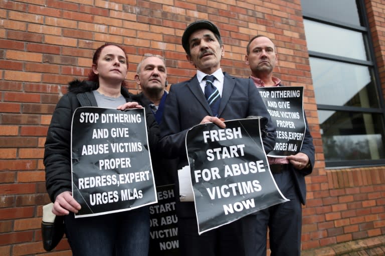 Alleged victims of historical institutional abuse pose outside the Crowne Plaza hotel in Belfast on January 20, 2017 as they arrive to attend the public statement on the publication of the Historical Institutional Abuse Inquiry Report