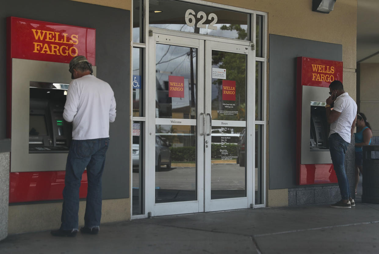 Customers use a Wells Fargo ATM at one of their bank branches in Miami, Florida. (Credit: Joe Raedle, Getty Images)