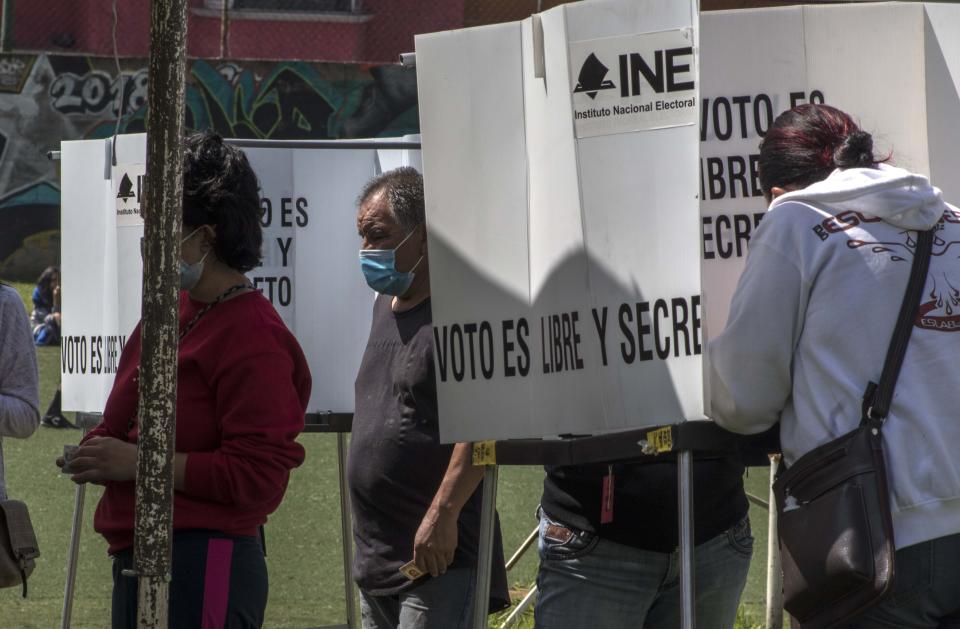 People cast their votes in a non-binding referendum on whether Mexican ex-presidents should be tried for any illegal acts during their time in office, in San Miguel Topilejo, Mexico City, Sunday, August 1, 2021. (AP Photo/Christian Palma)