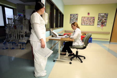 Registered dietitian Mariela Aviles (R) works on the menus for the young patients of the pediatric cardiovascular surgery area at the Cardiovascular Center of Puerto Rico and the Caribbean in San Juan, October 21, 2015. REUTERS/Alvin Baez