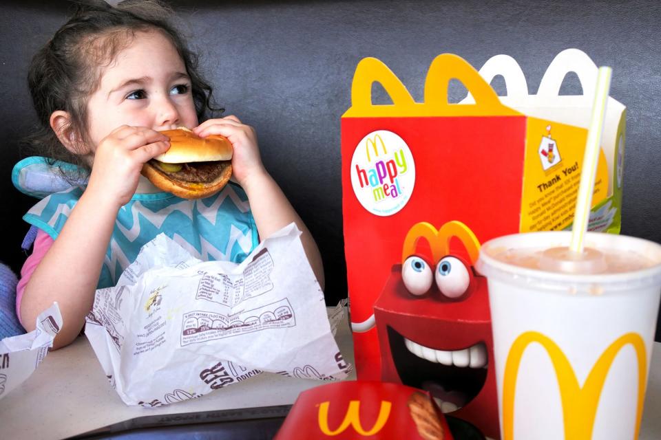 A young girl eats a McDonald's happy meal