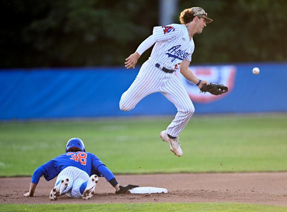 Chatham shortstop Marcus Brown goes up for the throw as Mitch Jebb of Hyannis dives back to second during this July 13 game in Chatham.