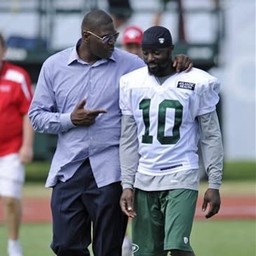 Former New York Jets receiver Keyshawn Johnson, left, talks with Jets wide receiver Santonio Holmes after practice on opening day of their NFL football training camp Friday, July 27, 2012 in Cortland, N.Y. (AP Photo/Bill Kostroun)