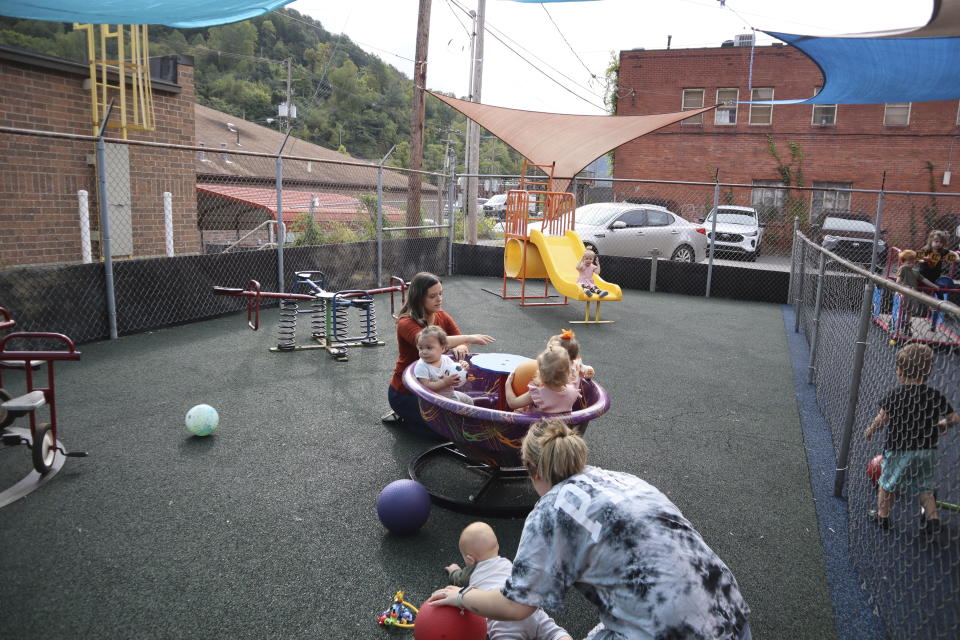 Daycare staff member Caitlyn Hammonds pushes toddlers on a teacup merry-go-round playground toy at Living Water Child Care and Learning Center in Williamson, W.Va. on Monday, Sept. 25, 2023. (AP Photo/Leah Willingham)