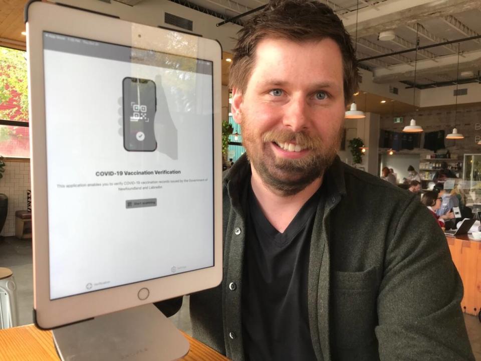 Phil Maloney, co-owner of Bannerman Brewing Co. in St. John's, displays a computer tablet that his staff will use to verify that patrons entering the business are fully vaccinated. (Terry Roberts/CBC - image credit)