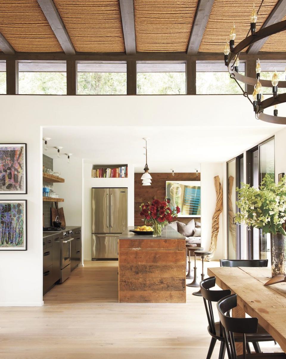 the kitchen island and shelving are made of reclaimed pine the refrigerator and range are by jenn air and the wood sculpture is from bali