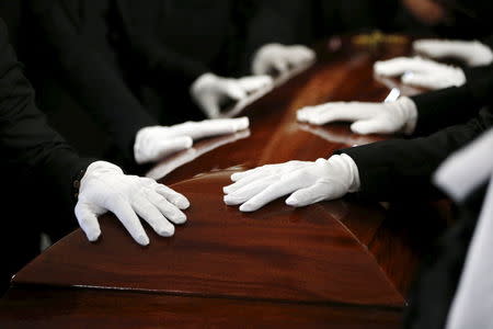 Pallbearers rest their hands on the casket of San Bernardino shooting victim Tin Nguyen during her funeral at Saint Barbara's Catholic Church in Santa Ana, California, December 12, 2015. REUTERS/Patrick T. Fallon -