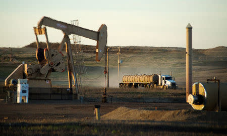 File Photo: A service truck drives past an oil well on the Fort Berthold Indian Reservation in North Dakota, November 1, 2014. REUTERS/Andrew Cullen/File Photo