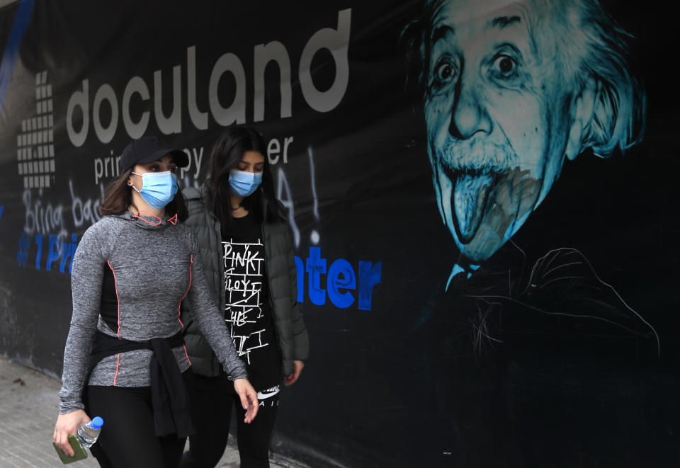 Lebanese women wear masks to help prevent the spread of the coronavirus, in Beirut, Lebanon, Wednesday, Jan. 27, 2021. Lebanon, a country of nearly 5 million and over 1 million refugees, is going through an unprecedented economic crisis that preceded the pandemic and restrictions imposed to combat it. (AP Photo/Hussein Malla)