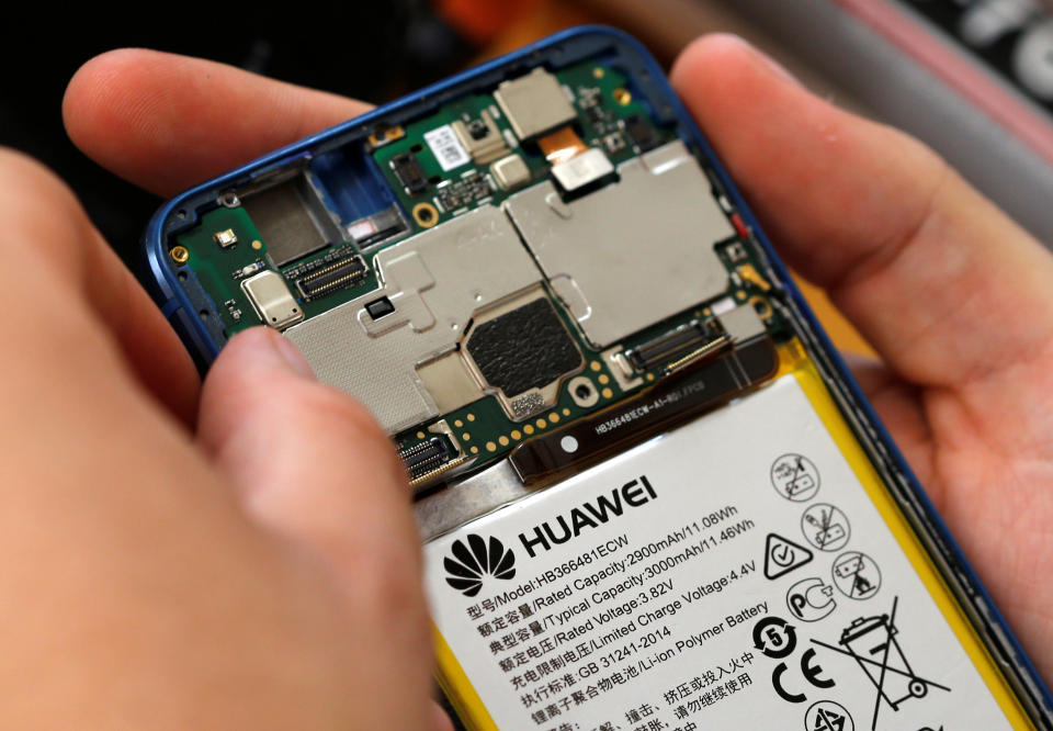 A worker refurbishes a Huawei cell phone at a workshop of the Oxflo company, specialised in refurbishment of broken European smartphones which will be resold and provided with a warranty as part of an eco-responsible approach, in Lusignac, France, June 20, 2019. REUTERS/ Regis Duvignau