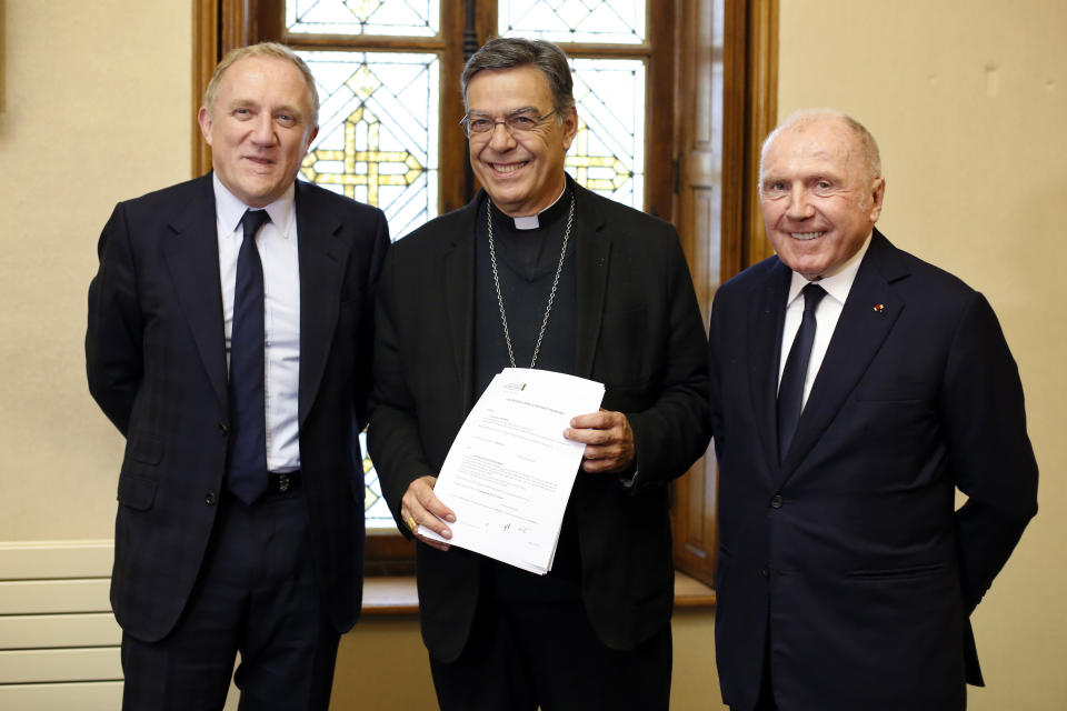 Francois-Henri Pinault, director general del grupo francés Kering, izquierda, su padre Francois Pinault, derecha, y el Arzobispo de París Michel Aupetit, centro, posan para una foto tras firmar un acuerdo para recaudar fondos para la reconstrucción de la catedral de Notre-Dame, en París, el martes 1 de octubre del 2019. (AP Foto/Thibault Camus)