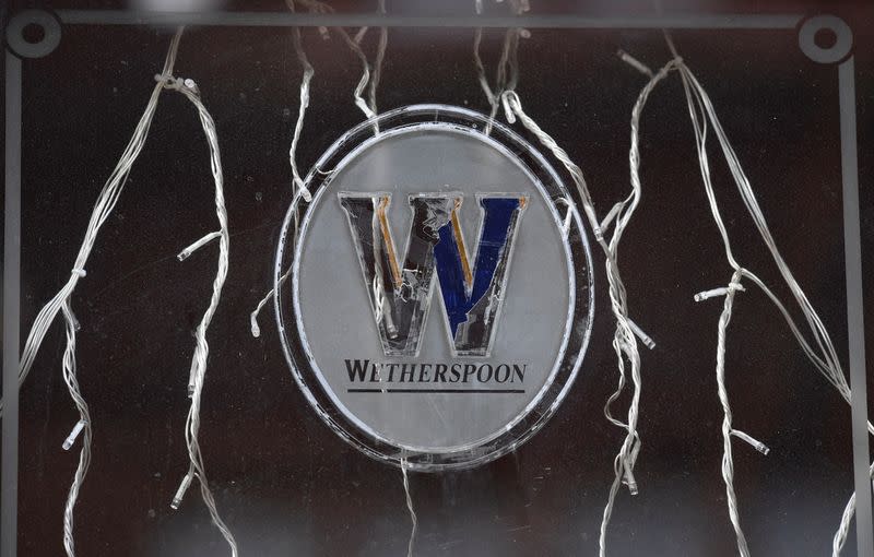 Signage is seen on a window of a closed Wetherspoon pub, London