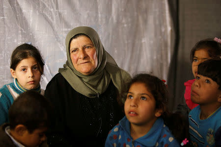 Amira Gharmoush sits with her grandchildren inside a tent in Herjelleh shelter in Damascus countryside, Syria March 30, 2018. REUTERS/Omar Sanadiki