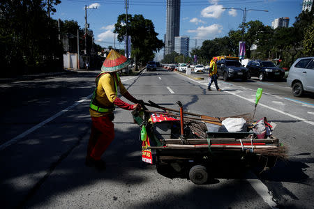 Alejandro Galasao, 58, street sweeper, pushes a cart with cleaning supplies at Quezon Avenue in Quezon City, Metro Manila, Philippines, November 14, 2018. Every day, Galasao sweeps trash and dirt off the roads in Quezon City, from six in the morning until two in the afternoon. REUTERS/Eloisa Lopez