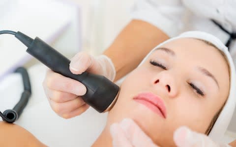 A woman receiving ultrasonic and laser face treatment at beauty salon - Credit: Gregor Bister/Getty Images&nbsp;