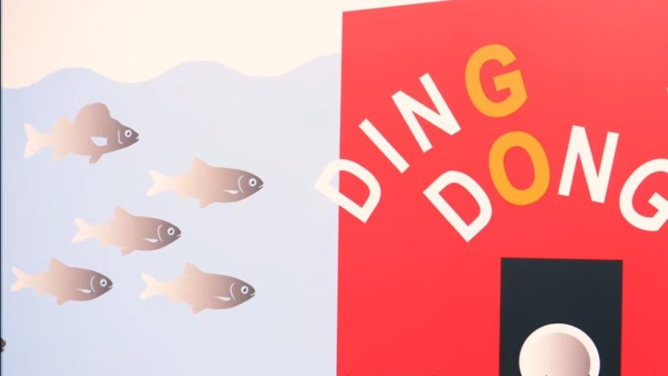 a photo of five animated fish on the left side in water. the right side is red and has the words ding dong on it with a button that is a fish doorbell