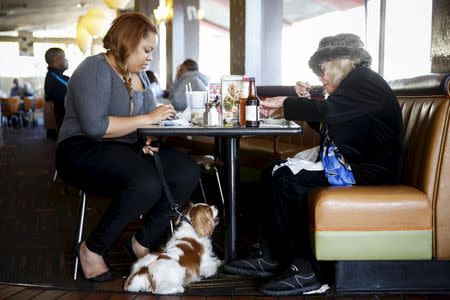 Customer Elaine Kasoff, (R), dines with her dog Rocky and Philecia Panton at Norms Diner on La Cienega Boulevard in Los Angeles, California May 20, 2015. REUTERS/Patrick T. Fallon