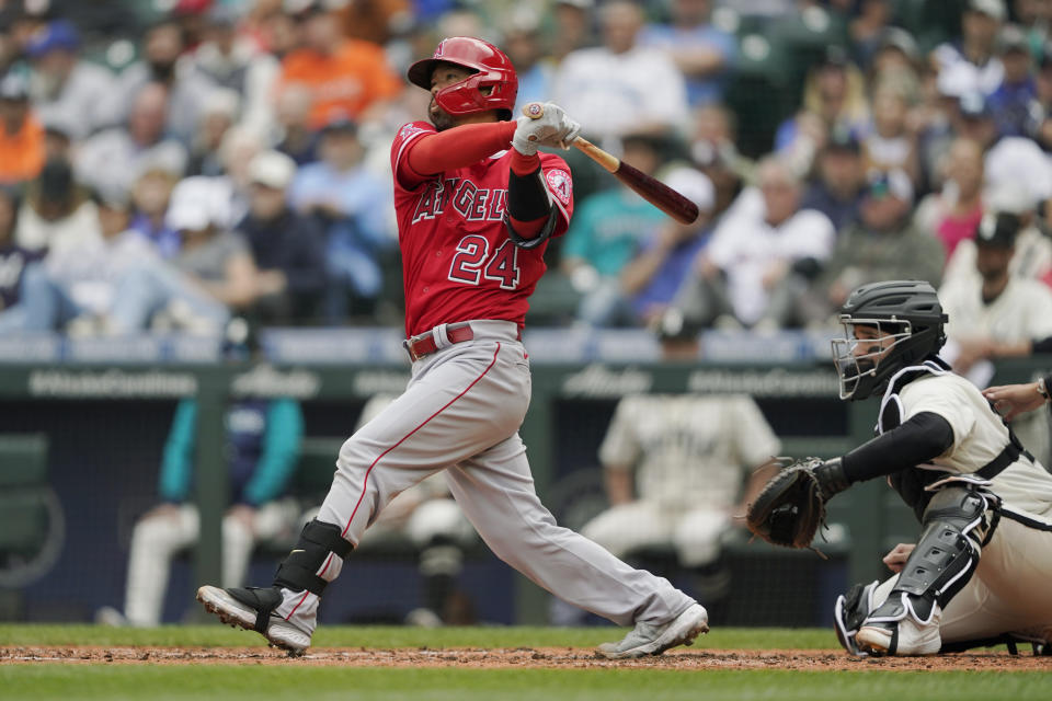 Los Angeles Angels' Kurt Suzuki follows through on a two-run double during fourth inning of the first baseball game of a doubleheader against the Seattle Mariners, Saturday, June 18, 2022, in Seattle. (AP Photo/Ted S. Warren)
