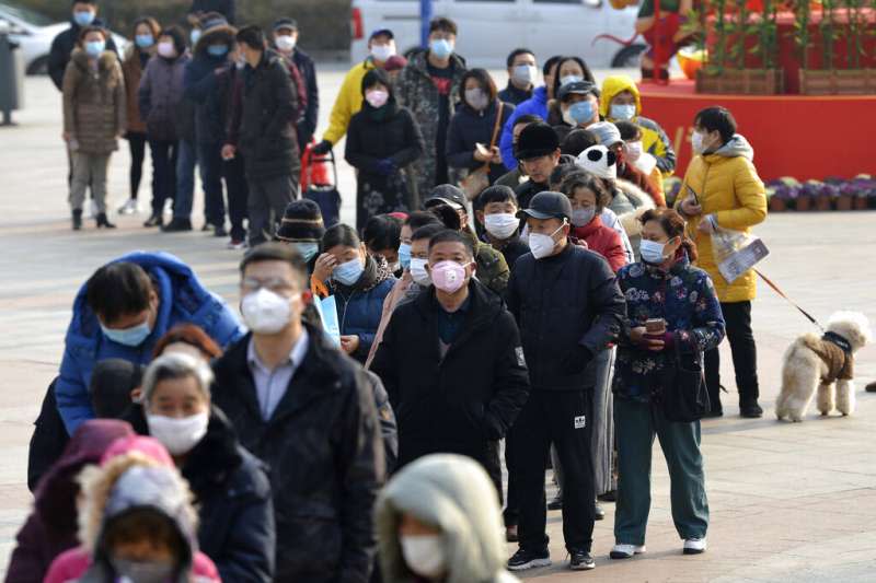 武漢肺炎疫情肆虐，南京市4日晚間發布公告全面實行「小區封閉管理」。圖為南京民眾正在排隊搶購口罩。（美聯社）