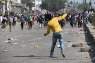 A protester hurl stones during a clash between anti CAA and pro CAA demonstrations, at Bhajanpura on February 24, 2020 in New Delhi, India. A Delhi Police cop and three civilians have died, a DCP-rank officer injured, a petrol pump torched, a number of houses, cars and shops burnt after clashes between pro and anti-CAA protesters in Maujpur and Jafarabad areas of North East Delhi. There was tension in the area after hundreds of anti-CAA protesters, mostly women, blocked a road near the Jaffrabad metro station connecting Seelampur with Maujpur and Yamuna Vihar. (Photo by Sanchit Khanna/Hindustan Times)