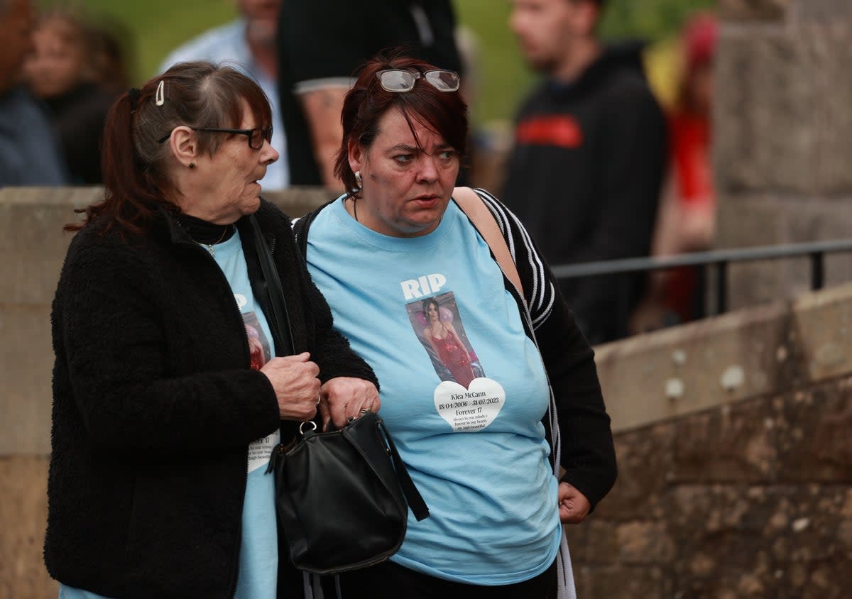 People wear T-shirts with a message and an image of Kiea McCann outside the Sacred Heart Chapel in Clones, Co. Monaghan for her funeral (PA)