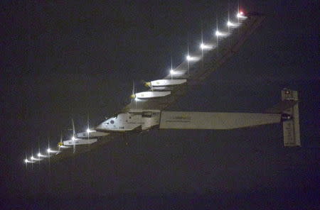 Solar Impulse 2, a solar powered airplane attempting a round-the-world flight, flies over Nagoya Airport after taking off from the airport to Hawaii, at Toyoyama town near Nagoya, central Japan, in this photo take by Kyodo June 29, 2015, early morning. REUTERS/Kyodo