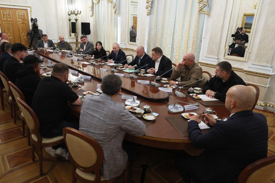 Russian President Vladimir Putin, background center, speaks during a meeting with Russian war correspondents who cover a special military operation at the Kremlin in Moscow, Russia, Tuesday, June 13, 2023. (Gavriil Grigorov, Sputnik, Kremlin Pool Photo via AP)