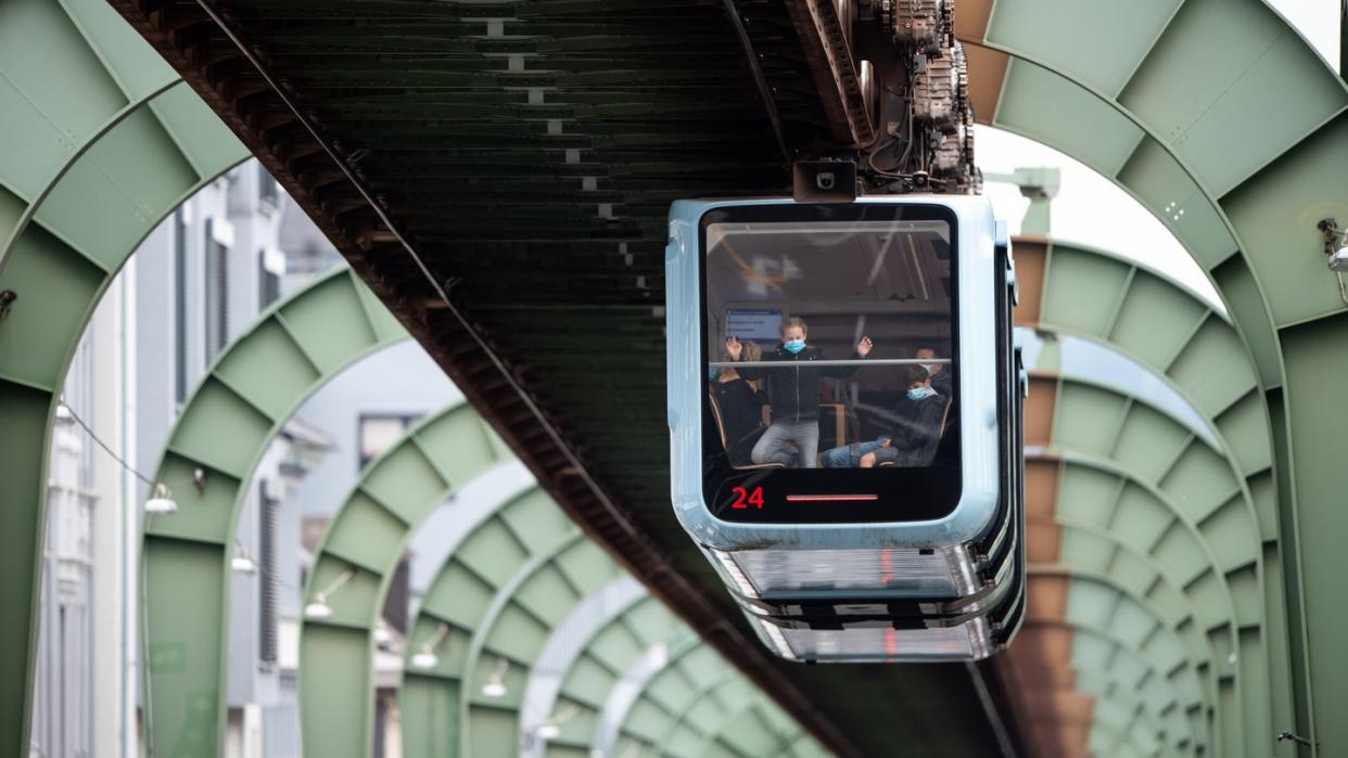 Das Wahrzeichen der Stadt Wuppertal, die Schwebebahn fährt über der Kaiserstraße in Vohwinkel entlang.