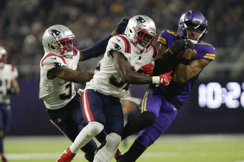 Minnesota Vikings wide receiver Justin Jefferson, right, catches a pass ahead of New England Patriots safety Devin McCourty, center, and cornerback Jonathan Jones, left, during the second half of an NFL football game, Thursday, Nov. 24, 2022, in Minneapolis. (AP Photo/Andy Clayton-King)